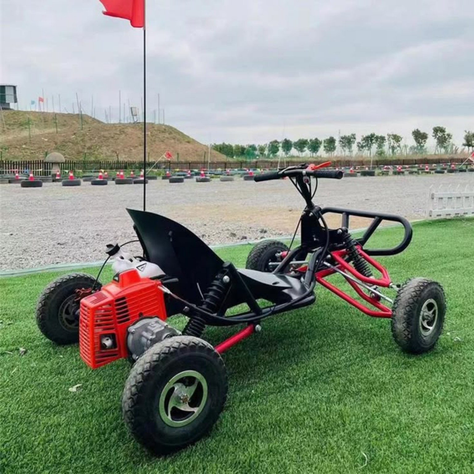 Kart infantil 90cc na grama ao lado de pista de kart